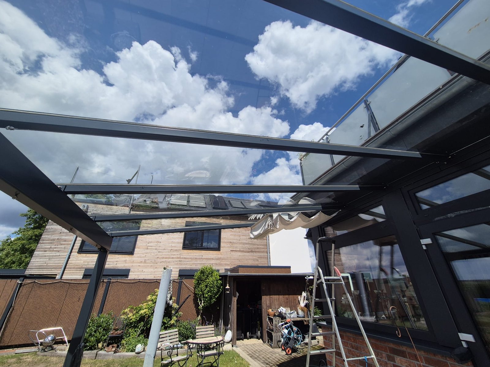 Blick durch das verglaste Terrassendach mit gerafftem Sonnenschutz – Interieur & Meer