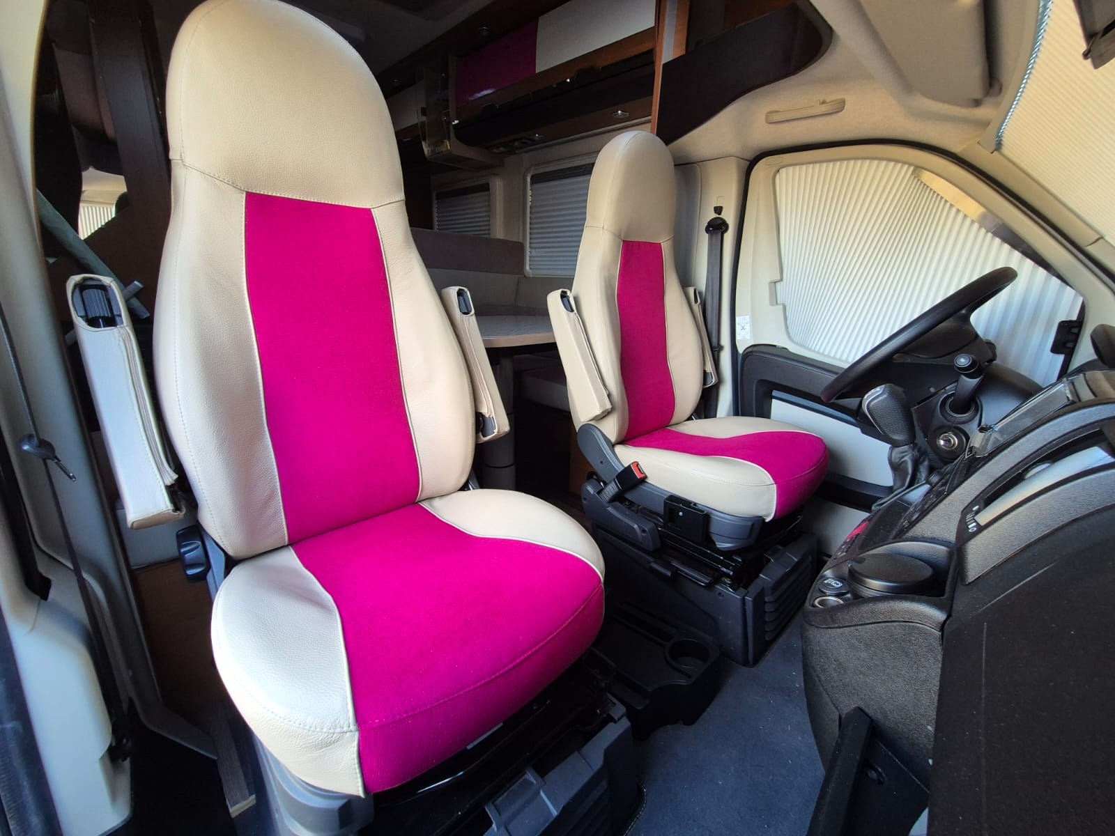 Fertig bezogene Wohnmobil-Sitze in cremefarbenem Echtleder mit pinkem Mittelfeld – Ergebnis von Interieur & Meer
